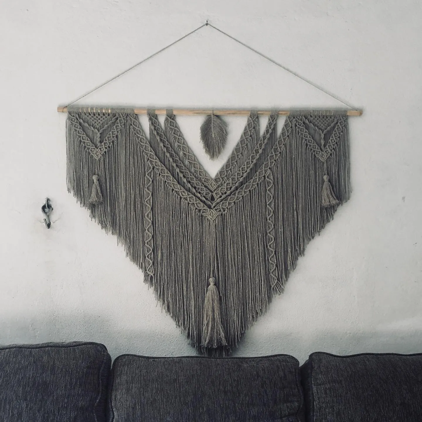 Pieza triangular gris con pendiente pluma