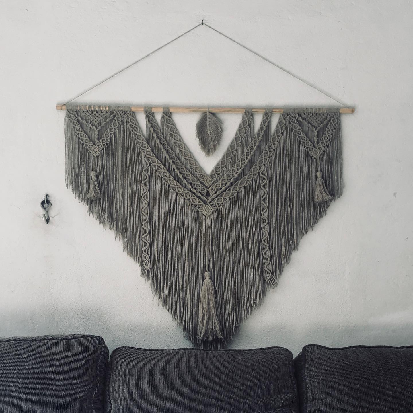 Pieza triangular gris con pendiente pluma